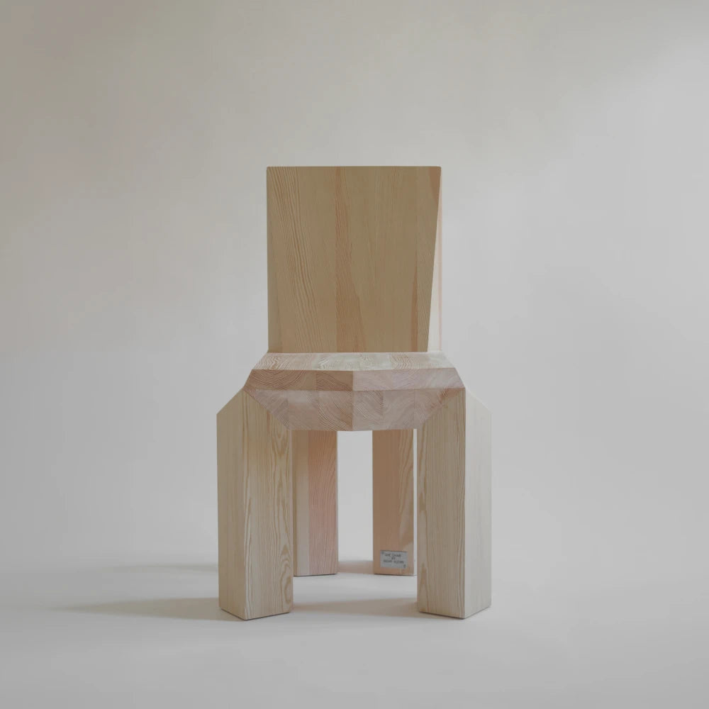 Front view of the Ode Chair Natural by Sizar Alexis, emphasizing its symmetrical structure, faceted seat edge, and visible natural grain.